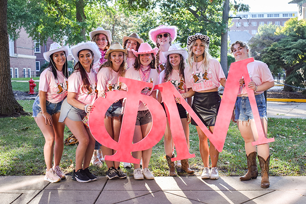 Group photo of sorority members dressed in pink shirts and hats.